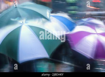 Apri gli ombrelloni colorati da vicino in una giornata piovosa. Scena stradale. Marciapiede bagnato e passaggio del traffico. Persone irriconoscibili Foto Stock