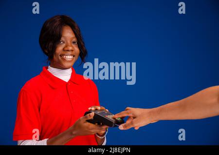 persona che passa la carta di credito su un dispositivo mobile per punti vendita Foto Stock