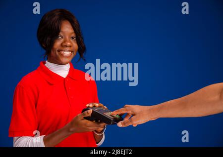 persona che passa la carta di credito su un dispositivo mobile per punti vendita Foto Stock