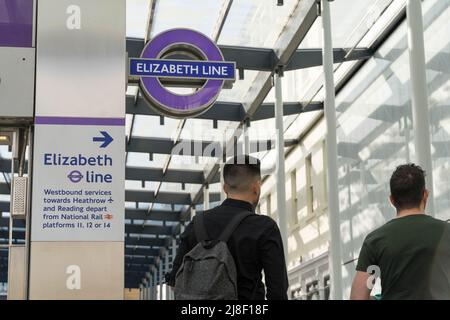 Due passeggeri camminano oltre il logo DELLA LINEA ELIZABETH, la nuova linea ferroviaria crossrail (linea viola), la stazione di Paddington London England UK Foto Stock