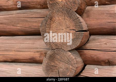 Un frammento di una parete assemblata in legno tondeggiante e dipinto di antiquariato. Primo piano. Foto Stock