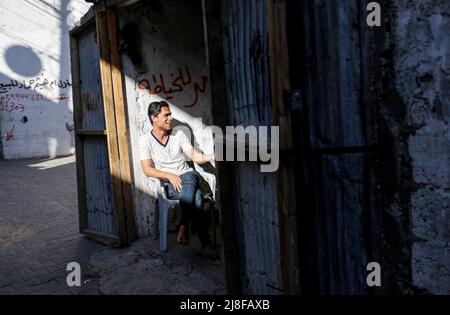 Gaza, Palestina. 15th maggio 2022. Un rifugiato palestinese siede di fronte alla sua casa nel campo di Jabalia il 74th anniversario della Giornata di Nakba nella striscia settentrionale di Gaza. È la data ufficiale della fondazione dello Stato di Israele, che ha spinto oltre 760.000 palestinesi in esilio o espulsione dalle loro case. Credit: SOPA Images Limited/Alamy Live News Foto Stock