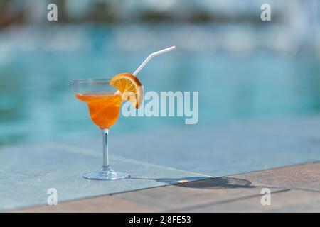 Bicchieri tiki tazza ripieni di bevande alcoliche con decorazioni in paglia  con frutta posta sul bordo del divano di legno del tavolo Foto stock - Alamy