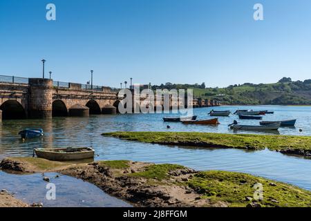 San Vicente de la Barquera, Spagna - 25 aprile 2022: Vista sul ponte di Maza e colorate barche a remi in legno Foto Stock