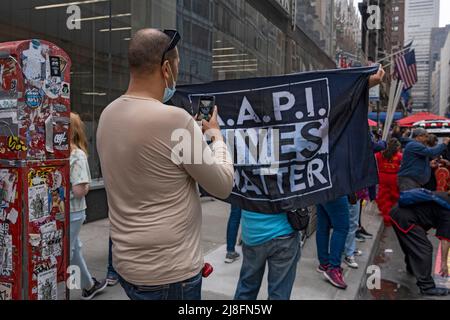 New York, Stati Uniti. 15th maggio 2022. Un uomo fotografa un segno un segno che dice 'A.A.P.I. Vive importanti' prima della prima Parata Culturale Asiatica americana e del Pacifico sulla Sixth Avenue a New York City. Credit: SOPA Images Limited/Alamy Live News Foto Stock