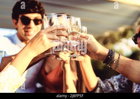 Amici alla moda che bevono e tostano al party sul tetto - giovani che si divertono insieme nel patio - amicizia stile di vita concetto con filtri luminosi - Foto Stock