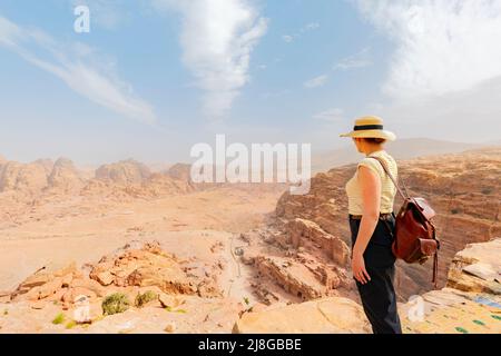 Il turista guarda le montagne rocciose rosse di Petra. Giordania Foto Stock