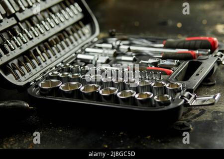 Set di cacciaviti intercambiabili per aprire la scatola di set con utensili da lavoro diversi tipi di teste e punte in acciaio metallico in officina. Foto Stock