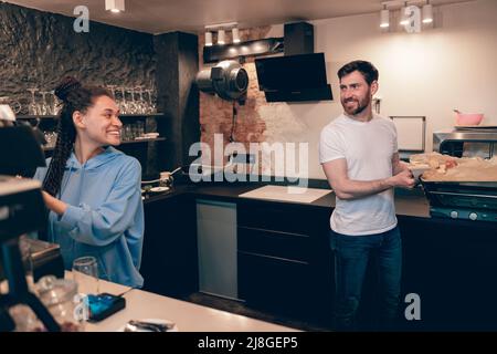 Giovane e ragazza allegra, collaboratori che sorridono e preparano l'ordine in un bar. Panetteria e caffè. Foto Stock