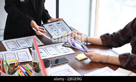 Gruppo di sviluppatori di siti Web che disegnano l'applicazione di progettazione di layout a reticolo per il telefono cellulare. Foto Stock