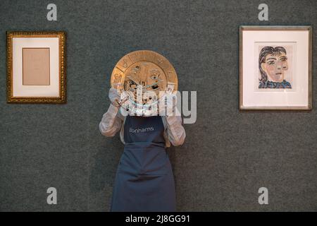 Londra UK, 16 maggio 2022. Pablo Picasso (1881-1973) Visage en forme d'Horloge, Estimate: ££30.000 - £50.000 background- L-R Tête d'homme, Estimate: £28.000 - £35.000,Tête de femme No 2. Portrait de Dora Maar, 1939 Estimate: £25.000 - £35.000. Bonhams asta visualizzazione di Picassomania. La vendita si svolge il 18 maggio presso Bonhams New Bond Street. Credit. amer Ghazzal/Alamy Live News Foto Stock