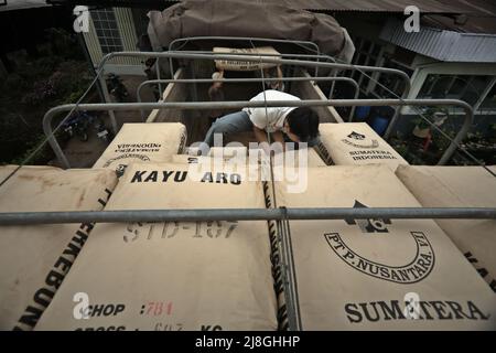 Lavoratori che caricano sacchi di tè su un camion presso la fabbrica di tè Kayu Aro nel villaggio di Kersik Tuo, Kayu Aro, Kerinci, Jambi, Indonesia. Foto Stock