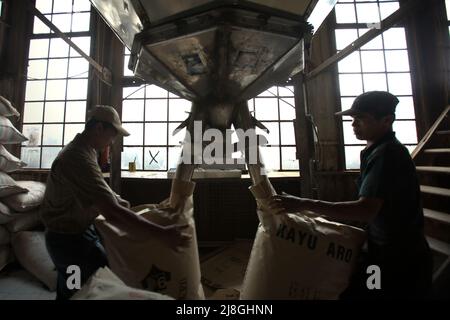 Lavoratori che impacchettano la polvere di tè in sacchi di carta presso la fabbrica di tè Kayu Aro nel villaggio di Kersik Tuo, Kayu Aro, Kerinci, Jambi, Indonesia. Foto Stock