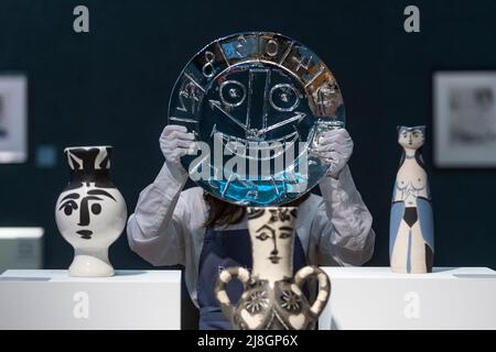 Londra, Regno Unito. 16 maggio 2022. Un tecnico presenta "Visage en forme d'Horloge", 1956, di Pablo Picasso (Est. £30.000 - £50.000) accanto alla ceramica in anteprima della vendita Bonhams Picassomania presso le gallerie Bonham's New Bond Street. Le opere di Pablo Picasso dalle stampe alla ceramica, le opere su carta alle fotografie saranno messe all'asta il 18 maggio 2022. Credit: Stephen Chung / Alamy Live News Foto Stock