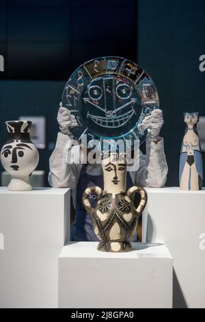 Londra, Regno Unito. 16 maggio 2022. Un tecnico presenta "Visage en forme d'Horloge", 1956, di Pablo Picasso (Est. £30.000 - £50.000) accanto alla ceramica in anteprima della vendita Bonhams Picassomania presso le gallerie Bonham's New Bond Street. Le opere di Pablo Picasso dalle stampe alla ceramica, le opere su carta alle fotografie saranno messe all'asta il 18 maggio 2022. Credit: Stephen Chung / Alamy Live News Foto Stock