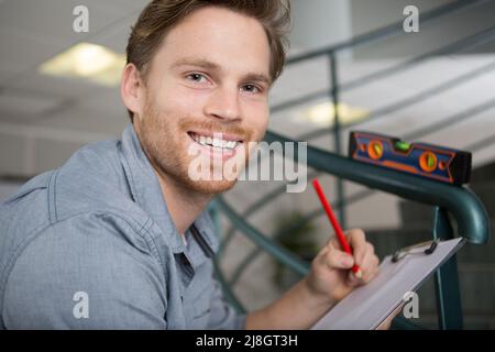 un lavoratore sorridente al lavoro Foto Stock