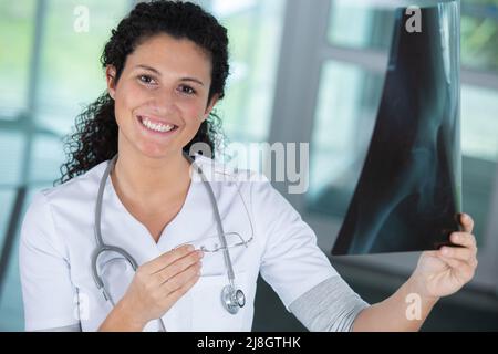 Donna sorridente medico guardando a raggi x Foto Stock
