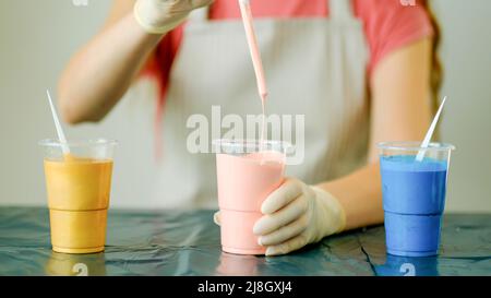 Tecnica Fluid ART. L'artista femminile lavora sulla pittura astratta di arte fluida. Foto Stock