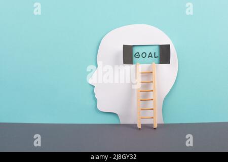 Silhouette di un uomo, finestra al cervello con la parola obiettivo, scala di successo, mentalità aperta, brainstorming per idee, disordine e concetto di psicologia Foto Stock