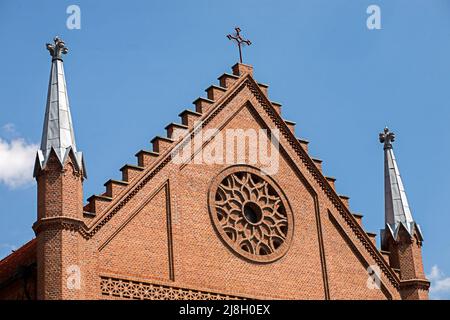 Vista di un frammento situato nella parte superiore anteriore della parete della chiesa contro il cielo blu. Turismo in Polonia. Foto Stock