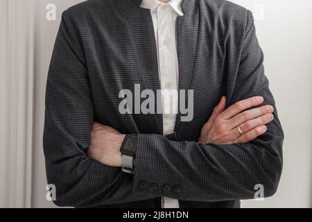 uomo in una camicia bianca e giacca vicino ad un muro di mattoni Foto Stock