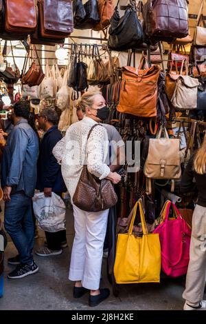 Firenze, Toscana, Italia - 15 aprile 2022: Acquisti di pelletteria al mercato Porcellino, Piazza del mercato nuovo Foto Stock