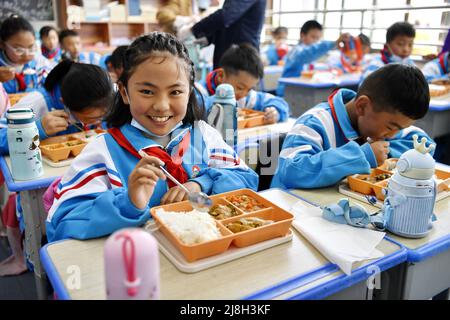 (220516) -- LHASA, 16 maggio 2022 (Xinhua) -- gli studenti di una scuola elementare di Lhasa Experimental Primary School hanno pranzo a Lhasa, nella regione autonoma del Tibet della Cina sudoccidentale, 12 maggio 2022. Con il funzionamento di un'azienda di ristorazione, circa 12.000 studenti di sei scuole elementari nel distretto di Chengguan di Lhasa ora godono di pranzi nutrienti. L'azienda di ristorazione, soprannominato "cucina centrale" per le scuole locali, è stata messa in funzione dal marzo di quest'anno per fornire pasti per le scuole elementari senza mense nel distretto. (Xinhua/Zhang Rufeng) Foto Stock