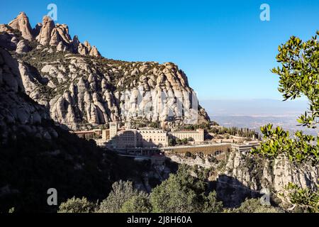 Monistrol de Montserrat in Catalogna con formazione rocciosa con cielo blu. Vista all'aperto dell'Abbazia di Santa Maria de Montserrat durante il giorno del sole. Foto Stock