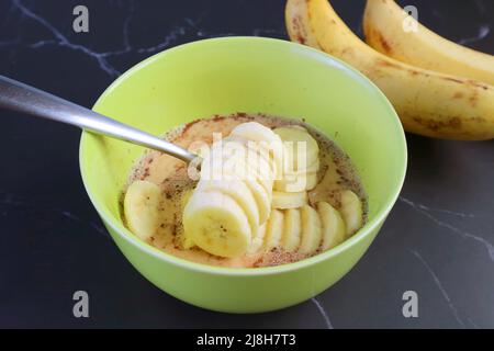 Fette di banane fresche mature nel composto per cuocere il pane di Banana Pudding Foto Stock