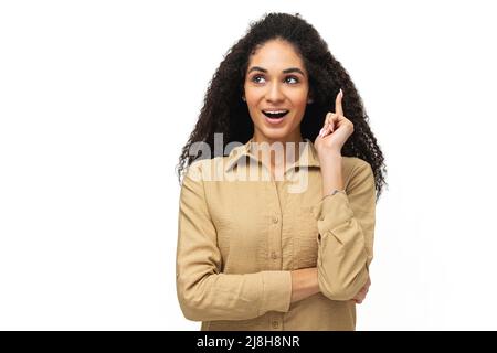 Felice giovane multirazziale curly sorridente donna 20s tenendo indice dito in su in segno di grande soluzione, afro-americana femmina ha fornito grande nuova idea isolata su bianco, eureka Foto Stock
