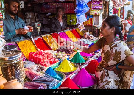 Mysore, Karnataka, India : una donna negozi per kumkum polvere colorata utilizzato per i punti bindi in una stalla nel mercato di Devaraja. Foto Stock