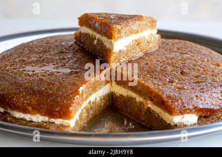 Pane kadayif su sfondo bianco. Fette di pane kadayif in un vassoio nome locale ekmek kadayif Foto Stock