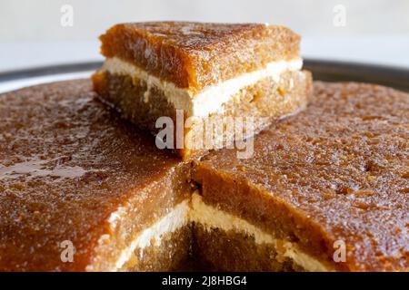 Pane kadayif su sfondo bianco. Fette di pane kadayif in un vassoio nome locale ekmek kadayif Foto Stock