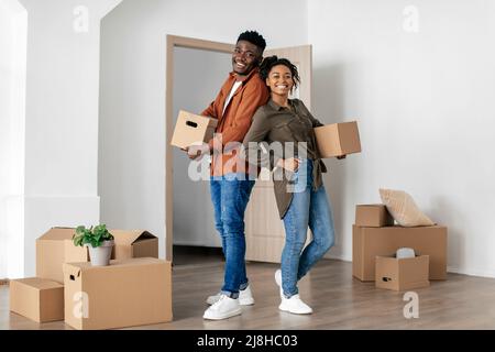 Joyful Black coniuge che tiene scatole mobili in cartone in New House Foto Stock