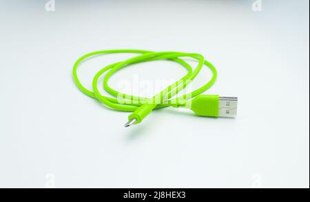 Cavo USB verde per smartphone isolato su sfondo bianco Foto Stock