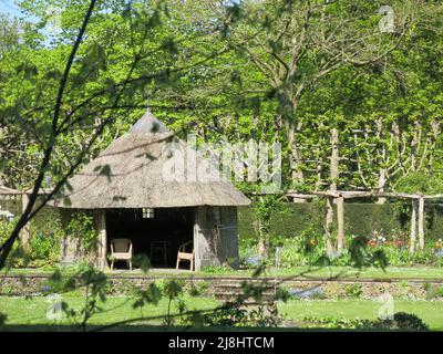 La casa d'estate con un tetto di paglia nei giardini di De Wiersse, un giardino anglo-olandese creato dalle famiglie De Stuaers e Gatacre. Foto Stock