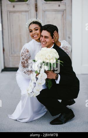 Multirazziale sposa e sposo abbraccio e hanno grandi sorrisi felici Foto Stock