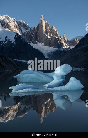 Un grande iceberg galleggia a Laguna Torre, con un perfetto rif al chiaro di luna Foto Stock