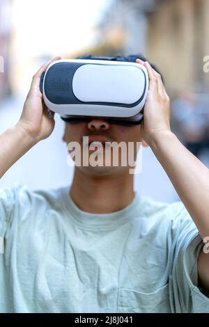 giovane uomo asiatico con i suoi occhiali di realtà virtuale Foto Stock