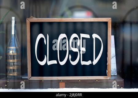Lavagna nella finestra di un ristorante con scritto 'chiuso'. Foto Stock