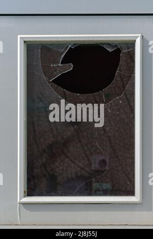 Doppio foro di vetro rotto sul telaio della finestra bianca Foto Stock