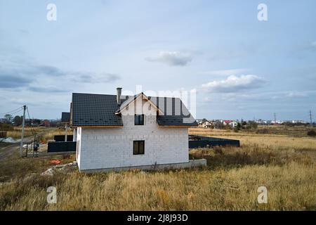 Vista aerea di casa incompiuta con pareti in calcestruzzo leggero aerato e telaio del tetto in legno rivestito con piastrelle metalliche in costruzione Foto Stock