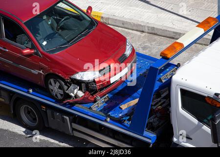 Vettura in crash caricata su un camion di traino. Danni al veicolo in seguito a incidente stradale Foto Stock