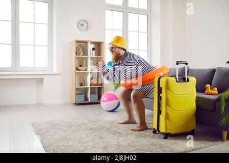 L'uomo grasso divertente rimane a casa e finge di avere una divertente vacanza estiva in spiaggia Foto Stock