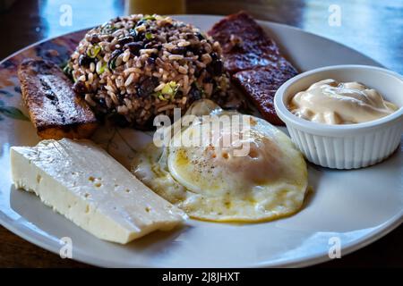 Gallopinto (fagioli neri e riso) tipica colazione Costa Rica. Servito con uova, pancetta e banana. Foto Stock