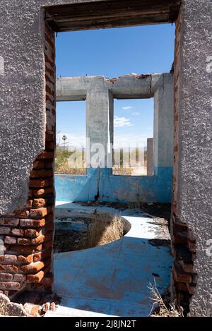 Guardando attraverso la porta di un edificio in stucco abbandonato nel deserto di sonora in Messico. Foto Stock