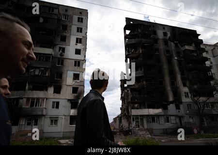 Kiev, Ucraina. 17th maggio 2022. I civili passano davanti a un edificio distrutto a Borodyanka. Con il fronte di guerra Russia-Ucraina che è stato spinto indietro verso est e sud-est, l'ex periferia occupata russa di Kyiv come Buca, Borodyanka e Hostomel ora devono essere visti di nuovo al mondo. Auto distrutte, edifici, carri armati e anche il più grande aereo del mondo è tra le vittime della guerra. (Foto di Dominic Chiu/SOPA Images/Sipa USA) Credit: Sipa USA/Alamy Live News Foto Stock