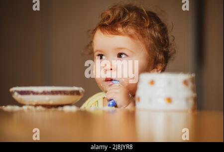 Bambino che mangia, concetto di nutrizione. Un bambino che mangia cibo da una ciotola. Foto Stock