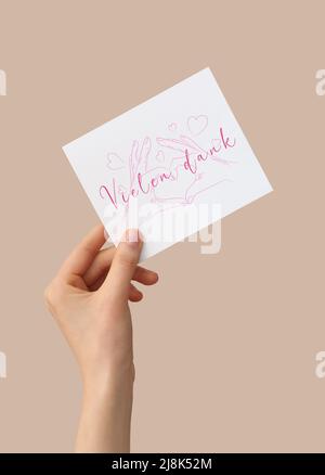 Scheda di tenuta femminile con testo VIELEN DANK (tedesco per un grazie molto) su sfondo a colori Foto Stock