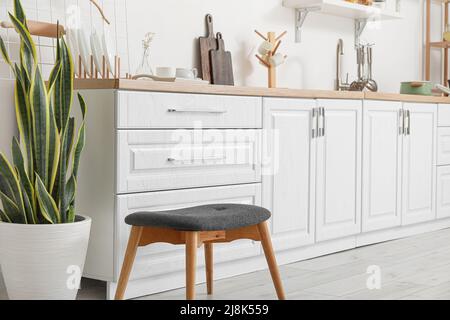 Interno di cucina luminosa con banconi bianchi e utensili Foto Stock